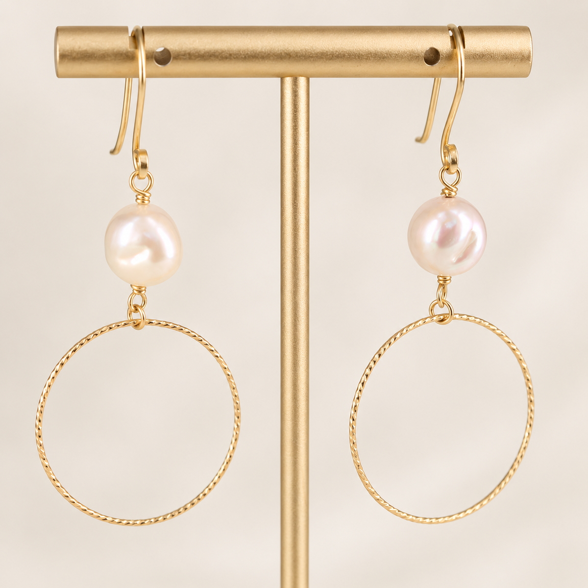 Angled view of Isolde freshwater pearl earrings showing the hand-formed circular hoops