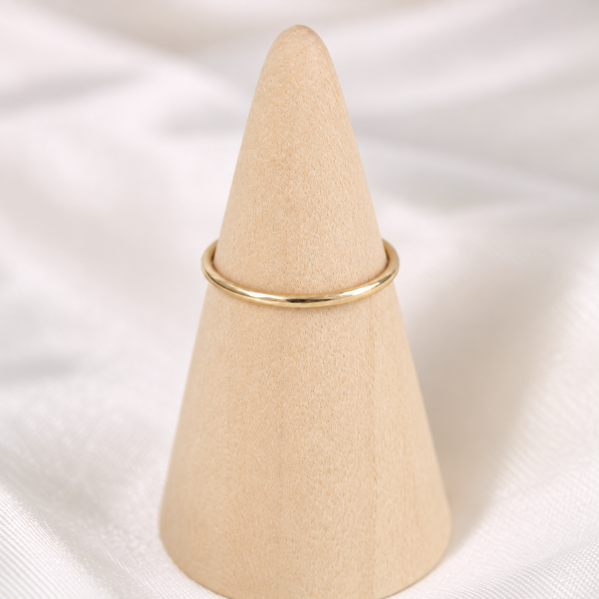 Simple 18-gauge gold-filled ring displayed on a natural wooden cone.
